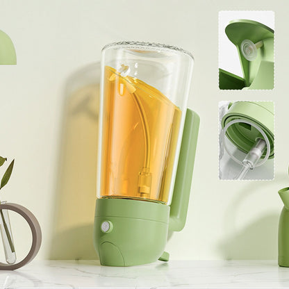 Green portable blender with a clear container filled with orange liquid on a light background.