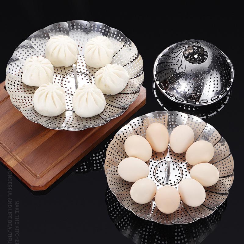 Metal steamer baskets with dumplings and eggs on a dark background
