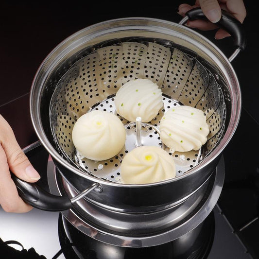 Steamed buns in a metal steamer basket held over a stove.